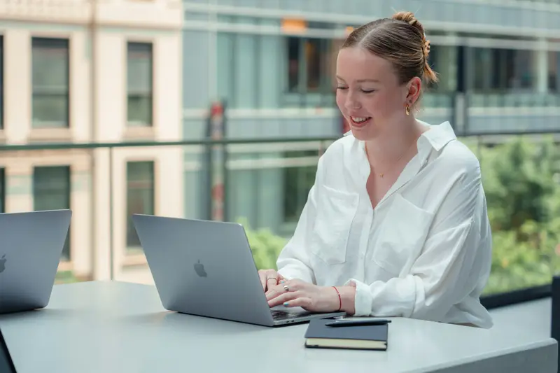 Frau führt am Laptop ein Videogespräch in einem hellen Büro