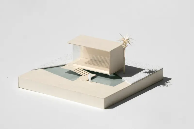 Weißes Architekturmodell eines kleinen Hauses auf hellem Grund