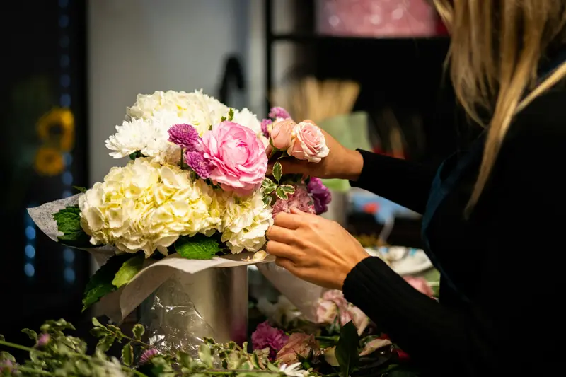 Floristin arrangiert Blumen in einer Vase