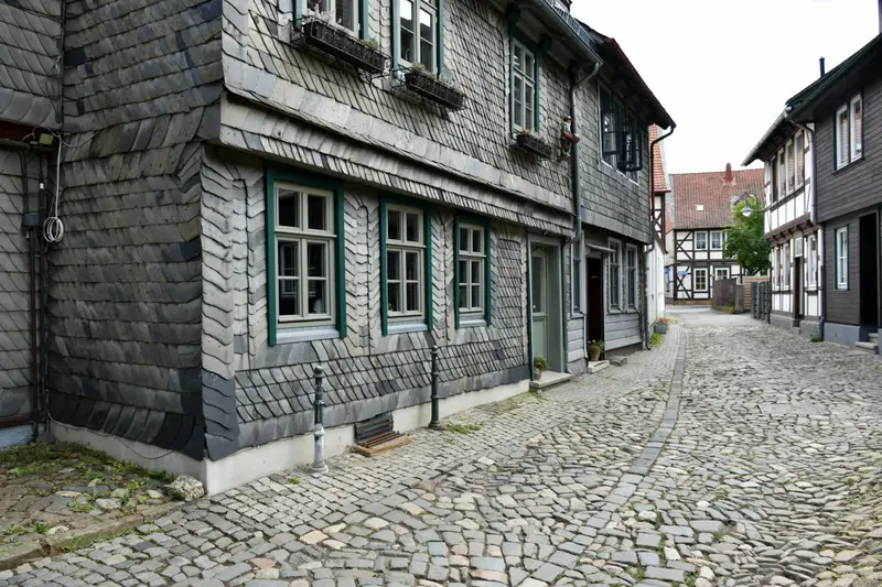Altbau mit Fassade aus Naturschiefer an einer gepflasterten Gasse