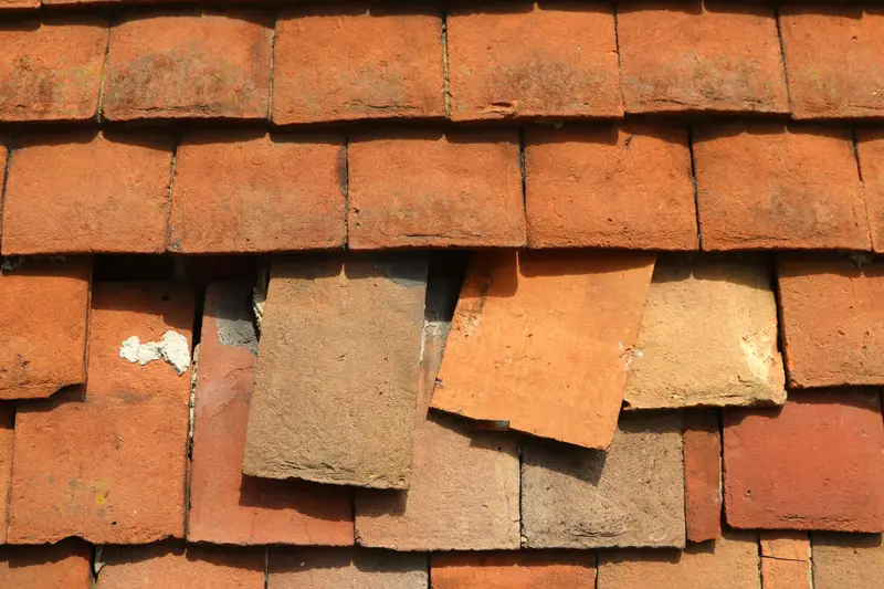 Verrutschte und gebrochene Biberschwanz-Ziegel nach einem Sturm