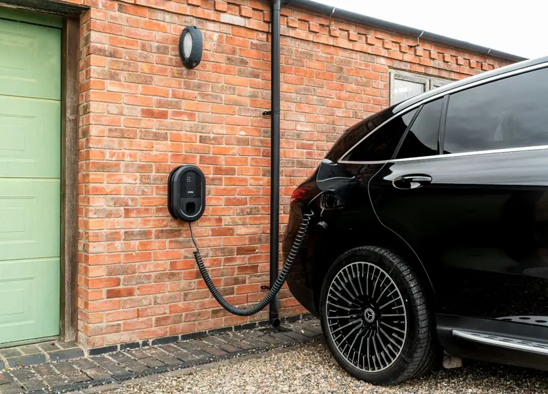 E-Auto lädt an einer Wallbox an der Garagenwand