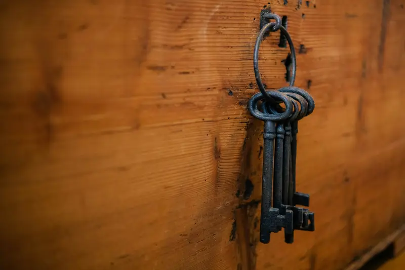Alte Schlüssel an einem Haken auf Holz