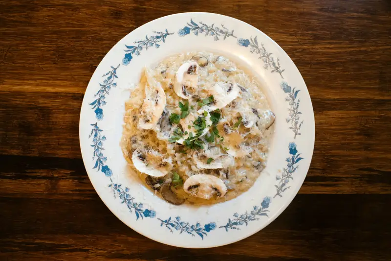 Steinpilz-Risotto auf einem Porzellanteller
