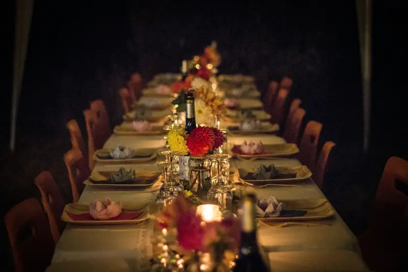 Lange Tafel mit Kerzen und Blumen, gedeckt für eine Feier
