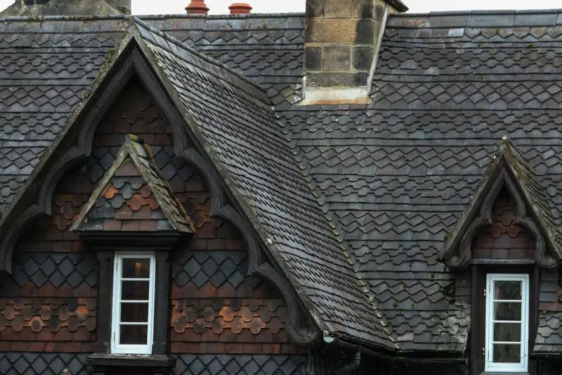 Schieferdach mit zwei Spitzgauben und Fischschuppen-Ornament