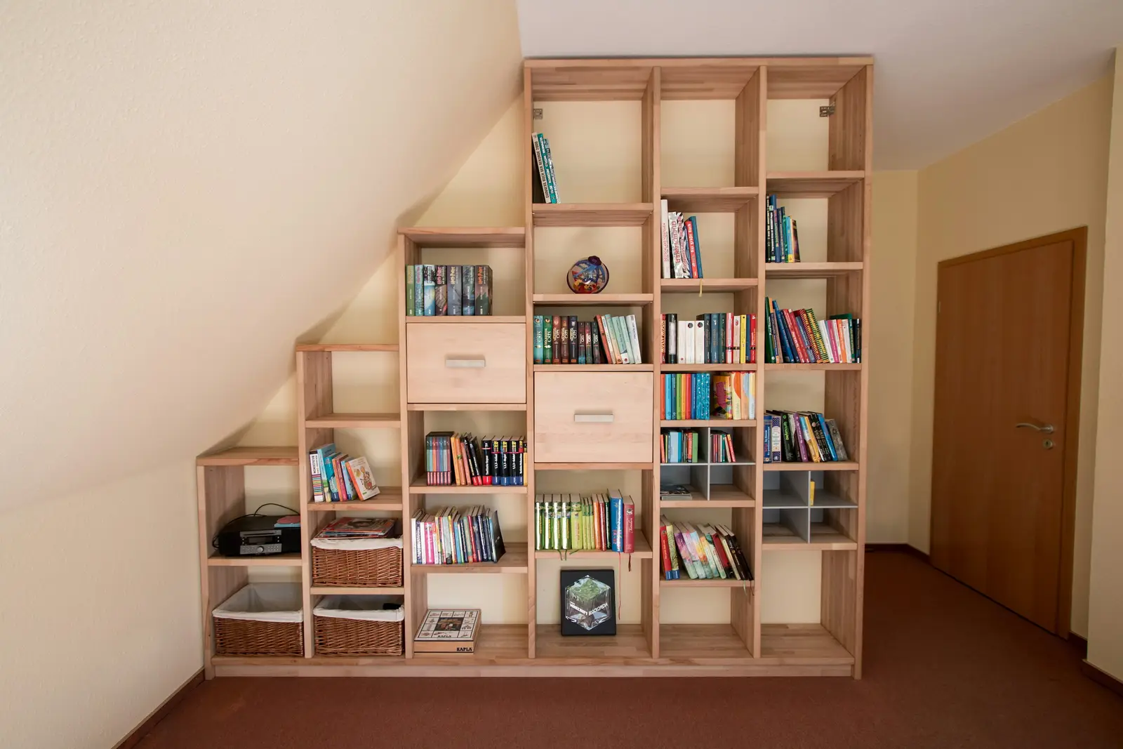 Bücherregal aus Eiche, das der Schräge unter der Treppe folgt