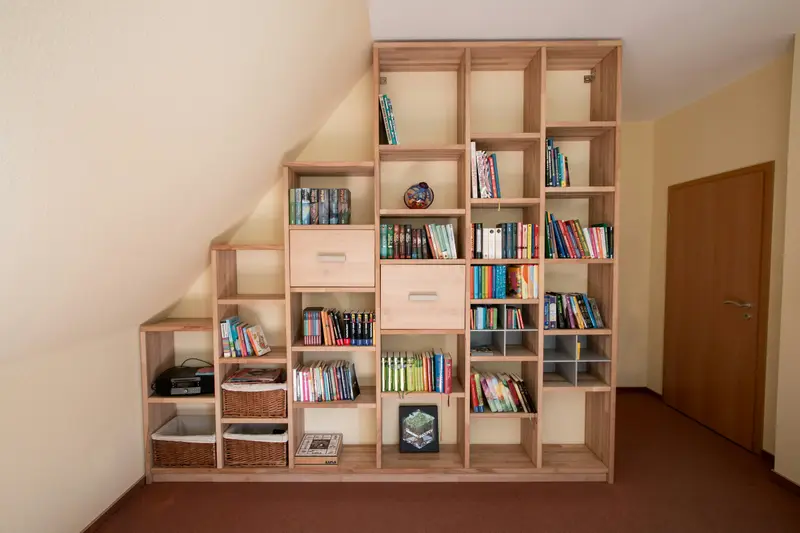 Bücherregal aus Eiche, das der Schräge unter der Treppe folgt